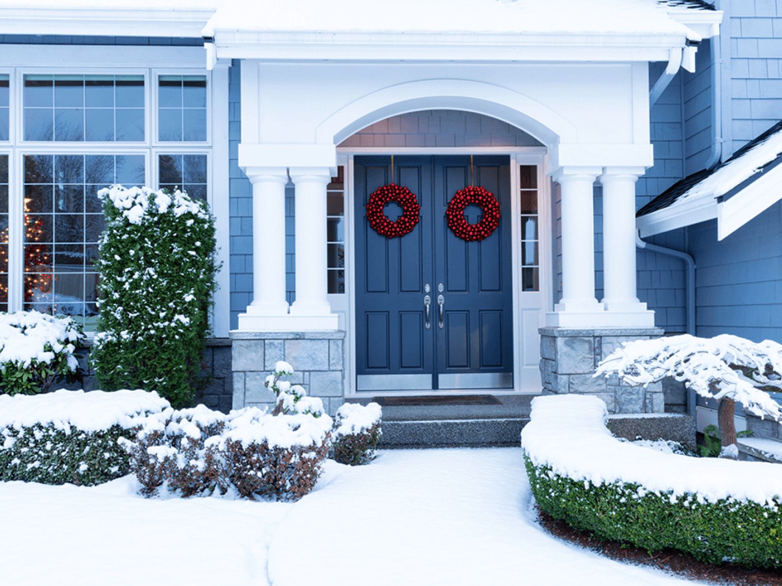 Front of nice home covered in winter snow.