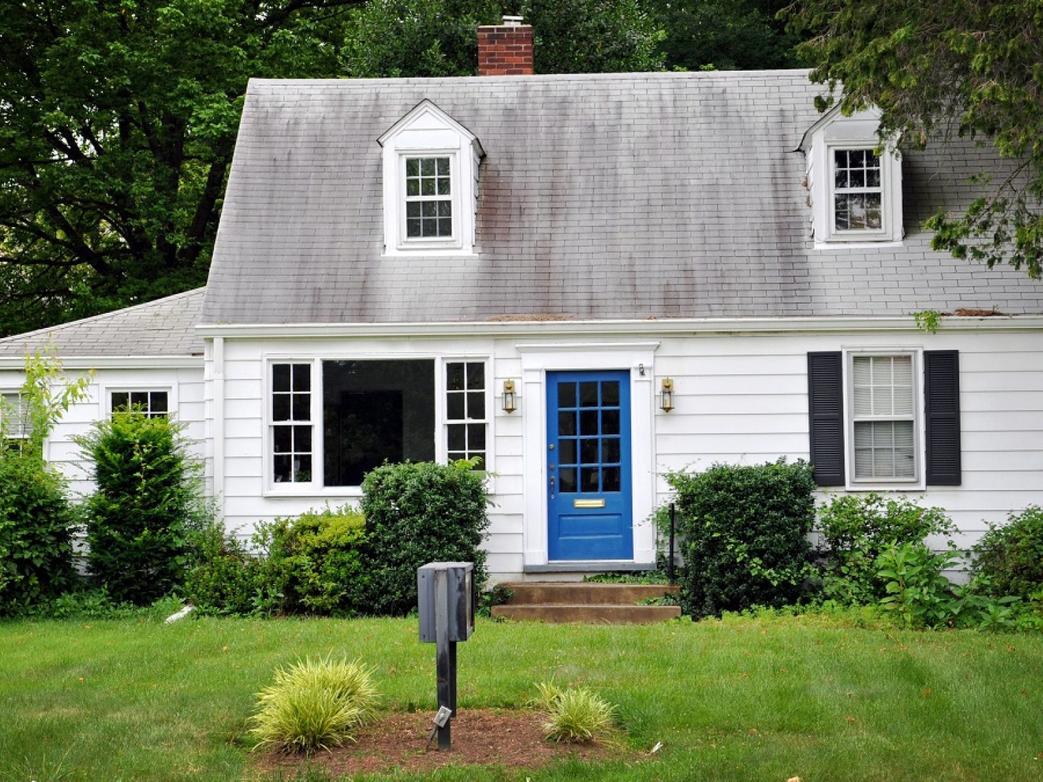 Front view of an older home that's slightly distressed.