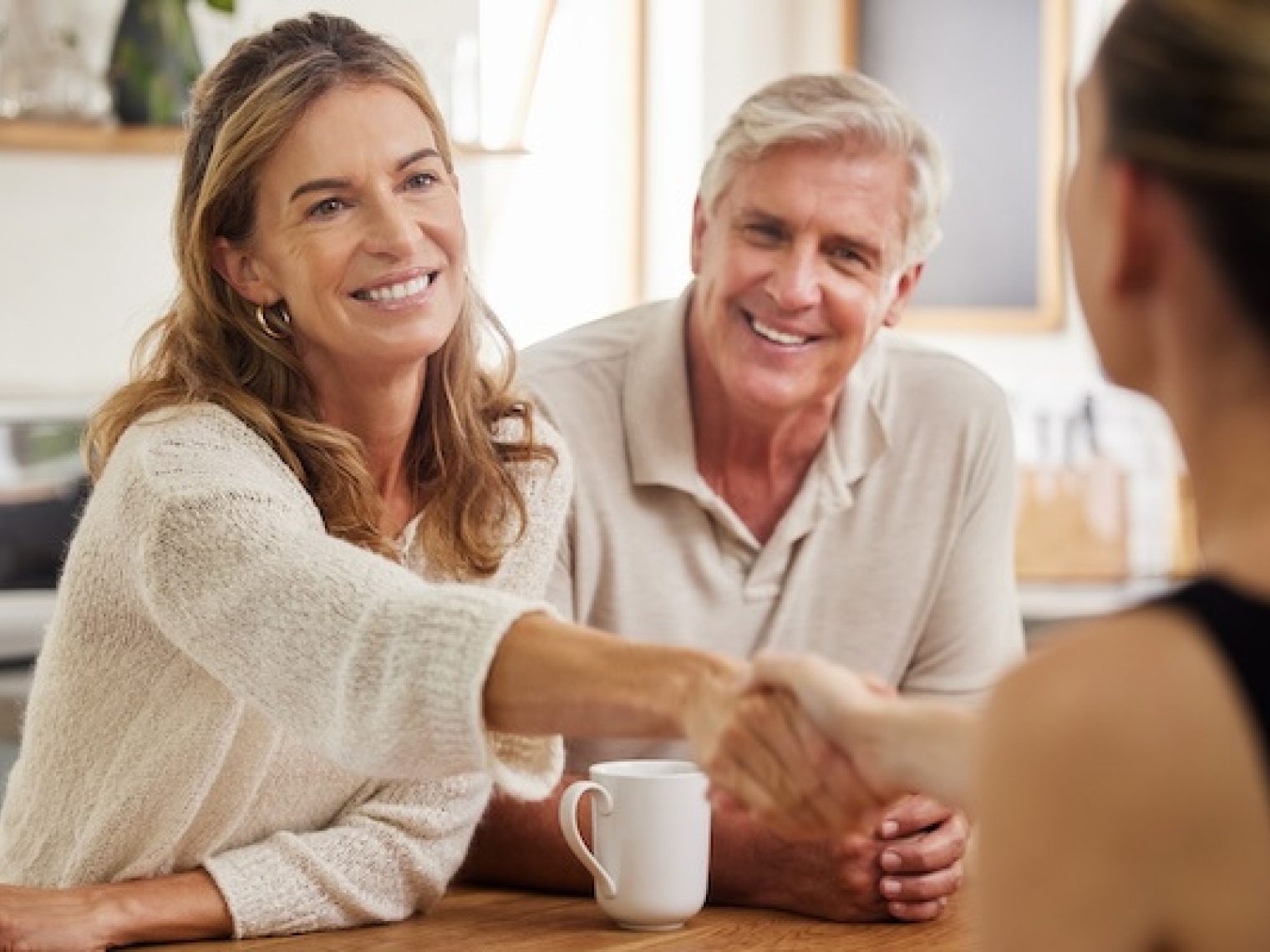 Couple shaking hands to make a deal with an agent.