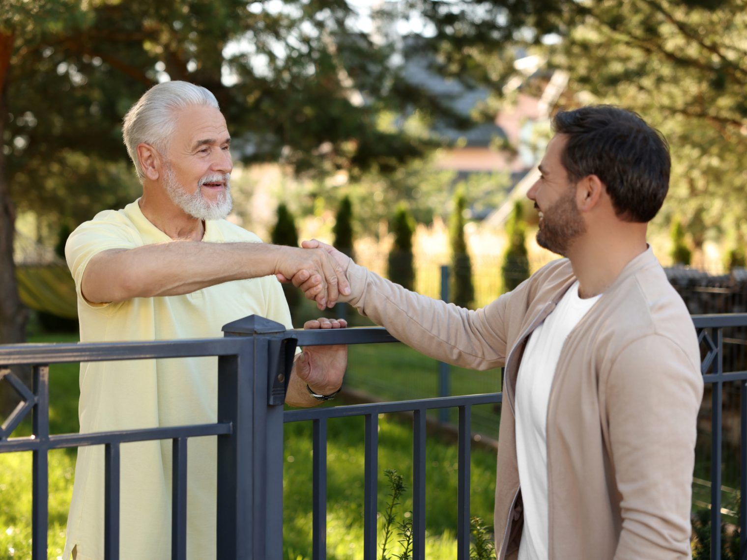 Neighbors talking over their shared fence.