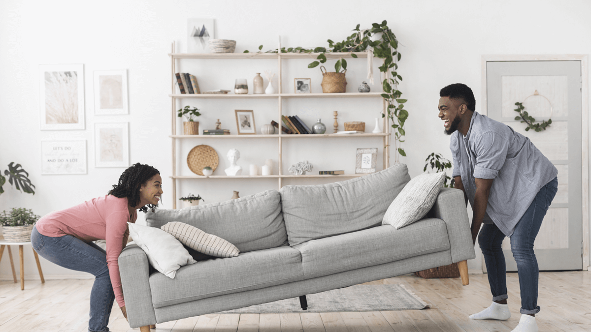 Couple moving gray couch.