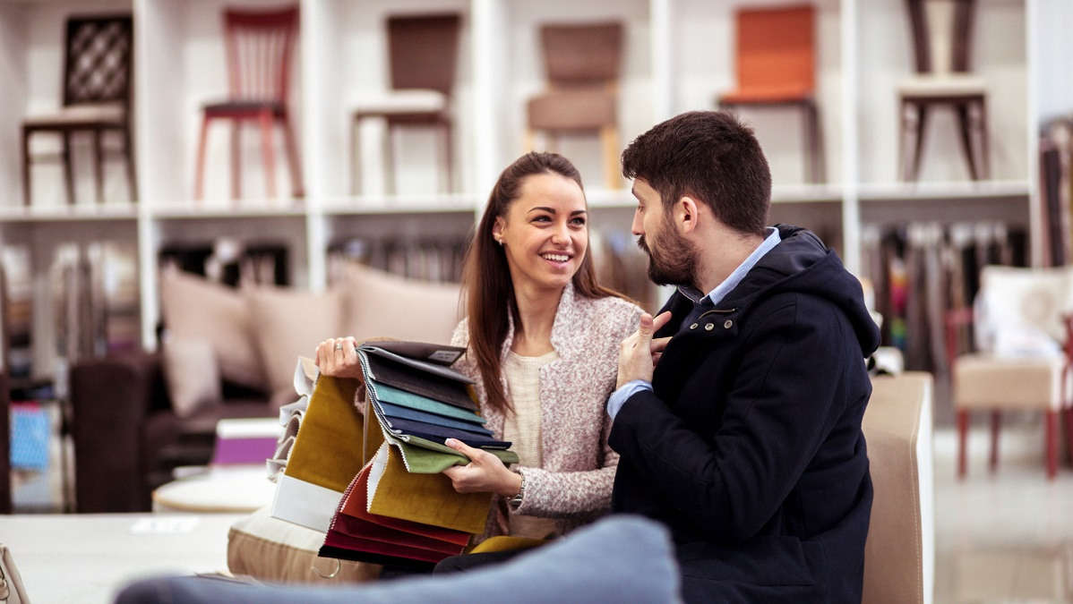 A couple in a store looking at textile swatches.